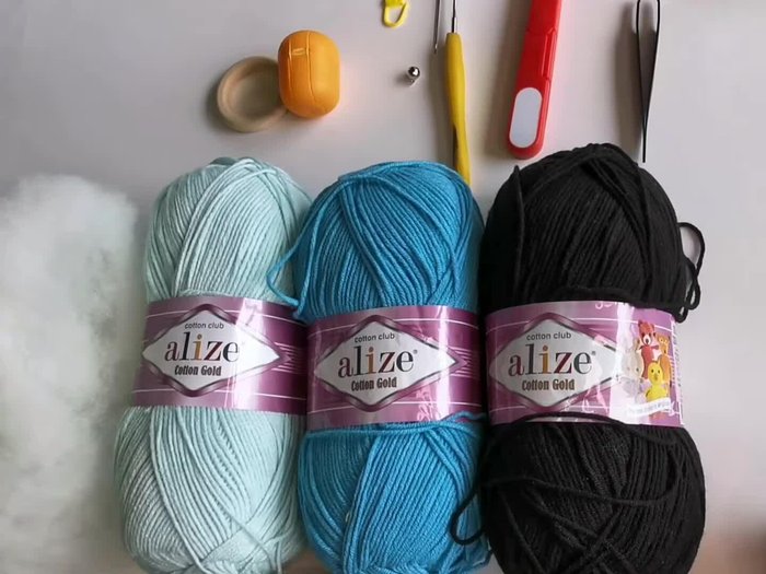 Gather materials: Choose two shades of blue yarn, black embroidery yarn (or another color), stuffing, a wooden ring, a bell, and other necessary tools.