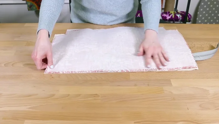 Attach outer fabric and lining: Fold layers (outer and lining facing each other). Sew bottom edges of outer pieces with 1/2 inch seam allowance. Sew bottom edges of lining pieces. Sew side seam, stopping before zipper teeth. Repeat for other side.