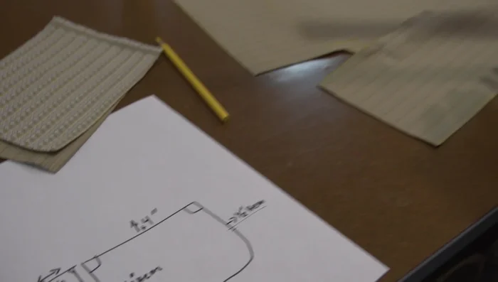 Create hems along the edges of the top fabric piece. Consider adding notches for seat back protrusion.