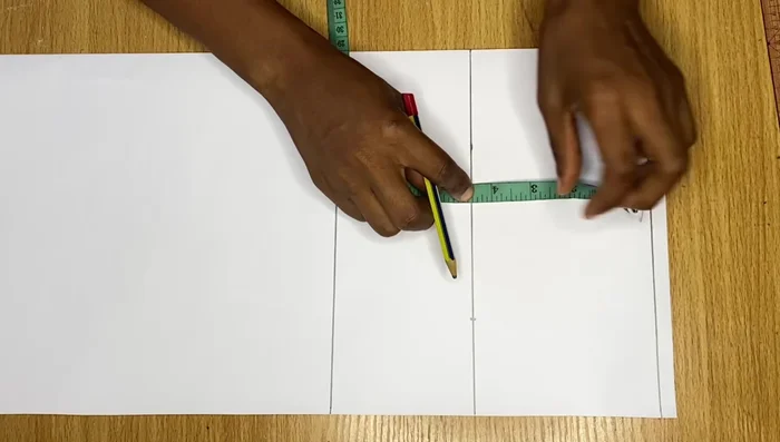 Measure straight from the top point (4 inches in) to the bicep line, divide by two, and mark the midpoint. Connect the top point, midpoint, and bicep point with smooth curves using a French curve or freehand.