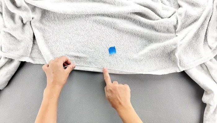 Hem the bottom edge of the cardigan and topstitch close to the inner edge.