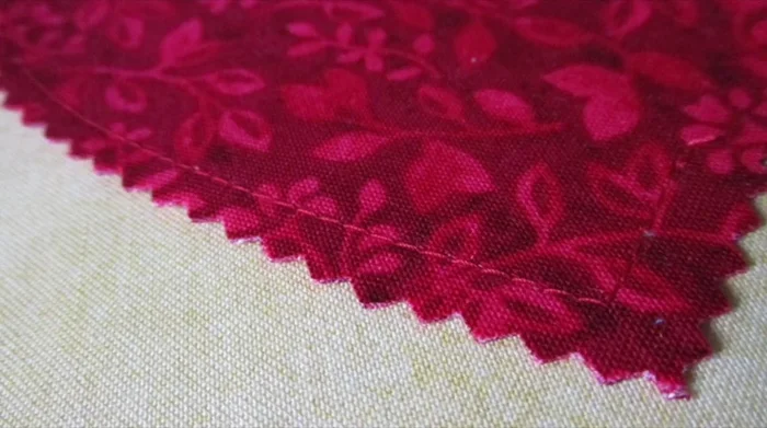 Remove the paper template and trim 1/4 to 1/2 inch outside the stitching line using pinking shears.