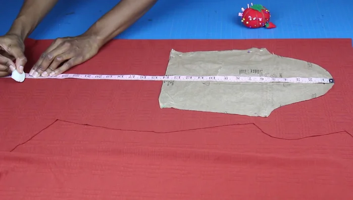Measure and cut the sleeve pieces, adding extra fabric for the hem. Draw a line down the center and mark the sleeve opening (7 inches). Create a curve from the top to the opening, and cut.