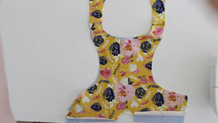 Place the lining fabric right sides together with the outer fabric, matching up all three layers around the neckline. Stitch around the neckline using a stretch stitch.