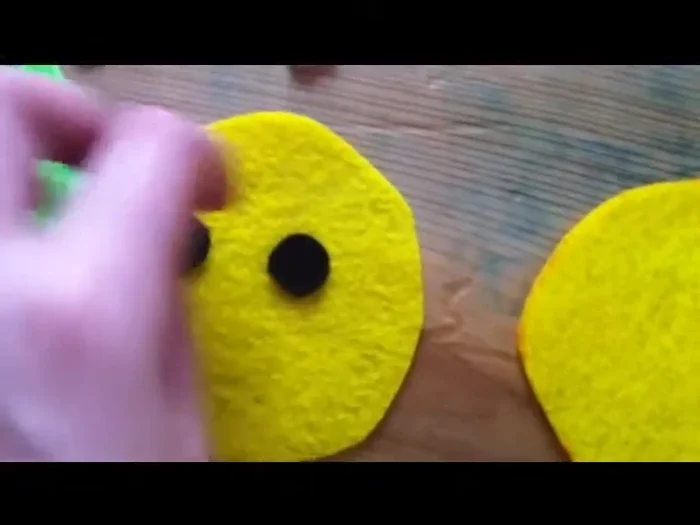 Sew the eyes and blush onto one of the yellow pineapple pieces using a backstitch.