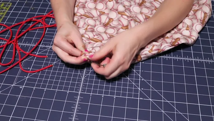 Tie off the paracord to the fabric loops and secure with a knot. Optional: Melt and press the ends together.