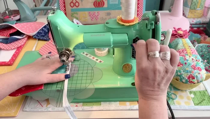 Assemble Bunting: Attach the scallops to the bias tape strip, one by one, ensuring the raw edges are enclosed. Backstitch at the beginning and end of each scallop.