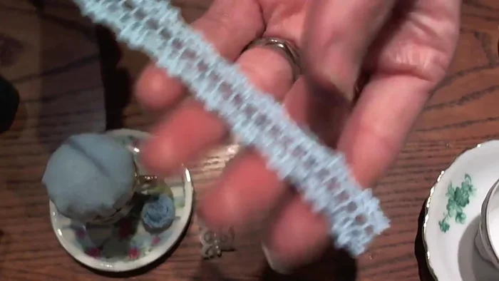 Add decorative trim: Cut a piece of ribbon, glue the edges together, and apply E6000 glue to the underside of the teacup's lip. Attach the ribbon, hiding the seam near the handle.