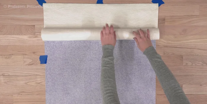 Place the batting smoothly on top of the backing, removing any wrinkles. For larger pieces, roll it out to work in sections.