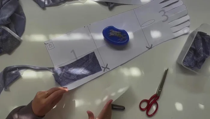 Attach the thumb section to the main glove piece.