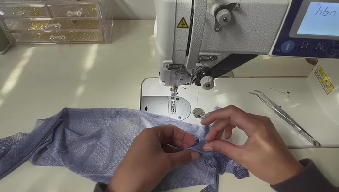 Attach the thumb section to the main glove piece.