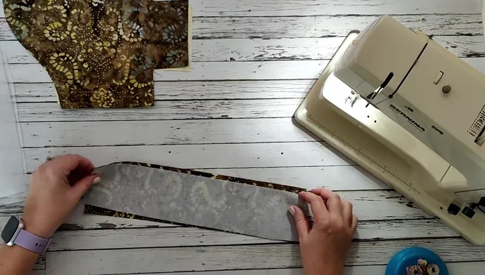 Cut out the strap (14" x 3.5"). Fuse interfacing to the wrong side of both the main fabric pieces and the strap.