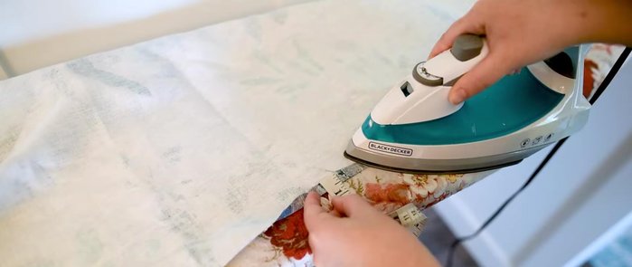 Press and sew 1-inch hems on the sides and bottom of the fabric, leaving the bottom hem open for dowel insertion.