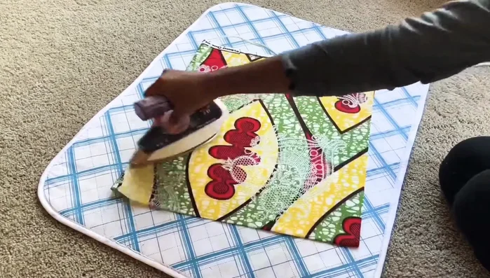 Cut fabric into precise squares using a rotary cutter and quilting square (or ruler). Fold fabric to maximize cuts.