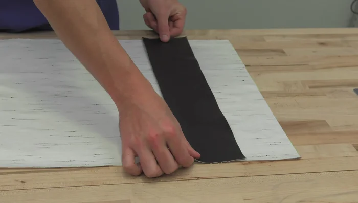 Sew the accent strip to the larger upholstery panel with outside surfaces facing each other. Use pins to prevent shifting. Backtack at the beginning and end. Seam allowance is about half an inch, stitch length is about 4 millimeters.