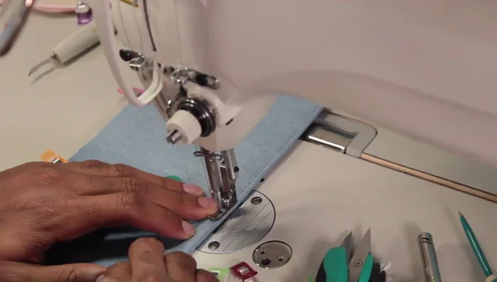 Sew on the side gusset pockets and flaps, adding a small panel piece to neaten the raw edges and simplify the flap attachment.