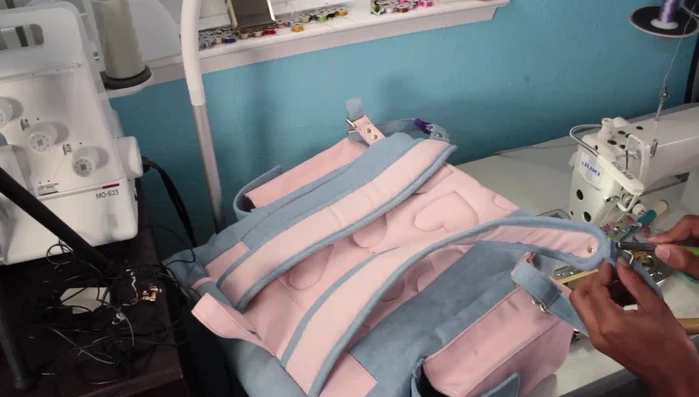 Attach the adjustable strap pieces and rivet them to the back panel for secure attachment.