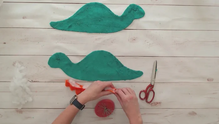 Pin spikes onto one body piece, aligning with markings. Baste them in place using a long basting stitch.