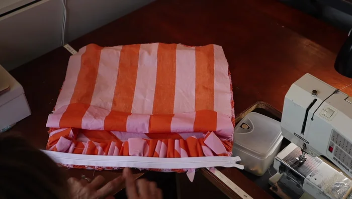 Pin and sew the zipper to one side of the pillow, leaving the pull facing down.