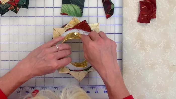 Add Finishing Touches: Once all layers are complete, add a piece of ribbon to the back of the wreath and secure it with pins. Attach your chosen picture to the back with pins.