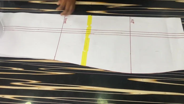 Crease the 1-inch dart on the front block to eliminate the dart on the lower part. Tape it down to secure the crease.