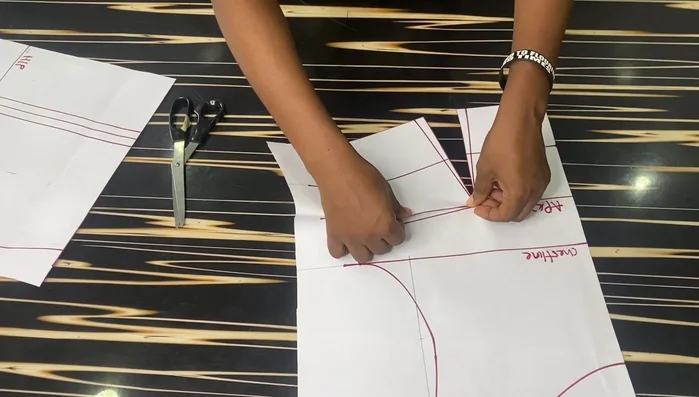 Crease the 1-inch dart on the front block to eliminate the dart on the lower part. Tape it down to secure the crease.