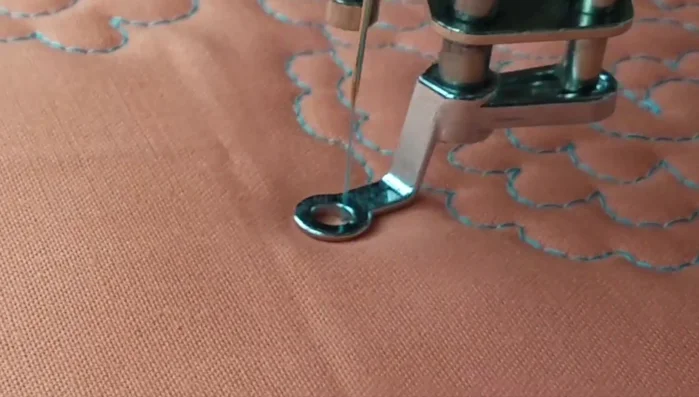 Begin a new flower by quilting a partial row, then creating the swirl and adding petals.