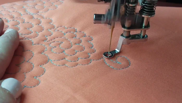 Work your way outwards, quilting small petal-shaped arcs around the swirl.