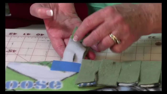 Working from one side, push the first fringe piece through the adjacent hole and pull it through. Repeat this until all fringe pieces are attached on one side, and then move to the next side and repeat.