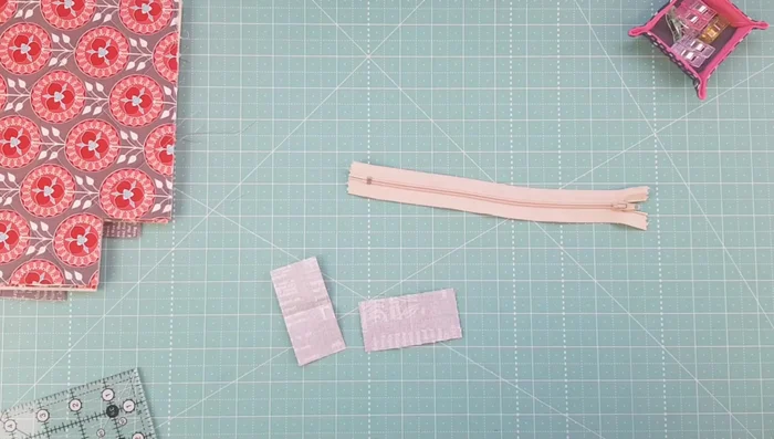 Prepare zipper tabs by folding in half and marking a stitching line.