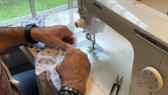 Attach lining sides: Sew the lining sides to the crown, using notches for alignment and a no-pin technique to maintain efficiency.