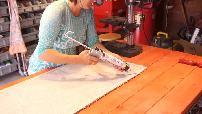 Apply lines of caulk across the entire back of the rug, approximately every three to six inches. You can make lines or dots; it doesn't affect the functionality.