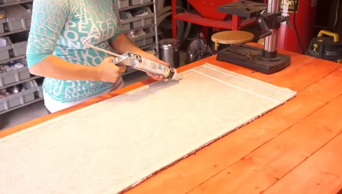 Apply lines of caulk across the entire back of the rug, approximately every three to six inches. You can make lines or dots; it doesn't affect the functionality.