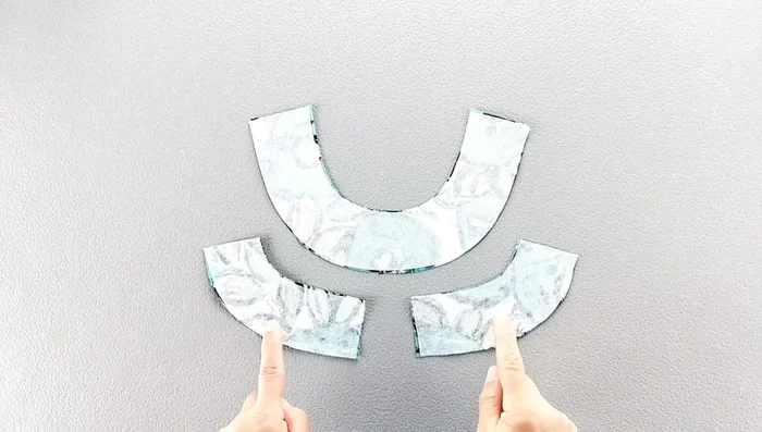 Fold the facing to the right side, pin in place along the neckline, matching shoulder seams, and sew.