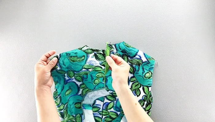 Fold the facing to the right side, pin in place along the neckline, matching shoulder seams, and sew.