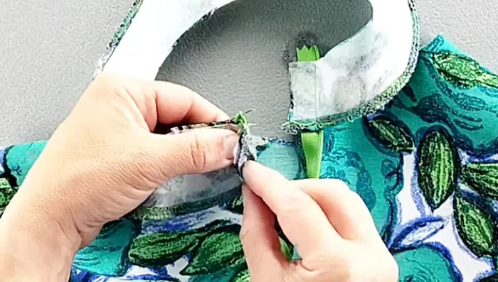 Fold the facing to the right side, pin in place along the neckline, matching shoulder seams, and sew.