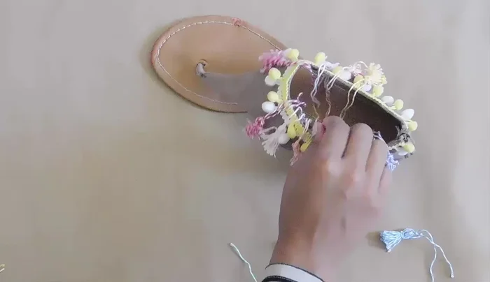 Arrange tassels and glue them to the sandal.