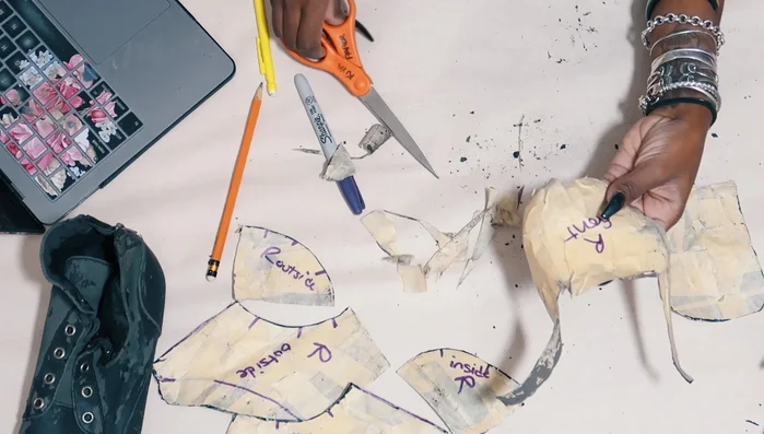 Cut fabric pieces using the pattern, adding seam allowance (though later removed).