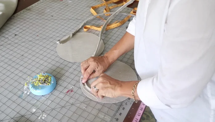 Pin the welt onto the circles, ensuring raw edges align, welt cording is inside, and the welt is positioned correctly.