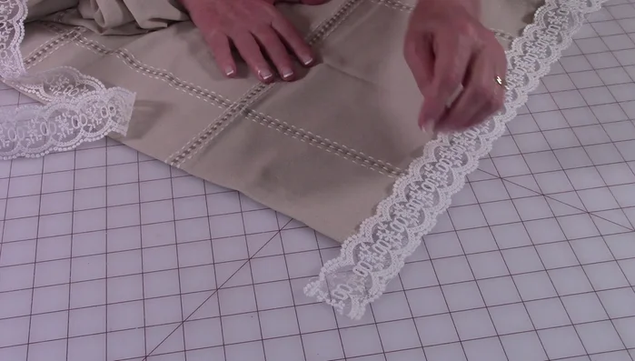 Extend the lace at least three inches beyond the edge on each side for mitered corners.