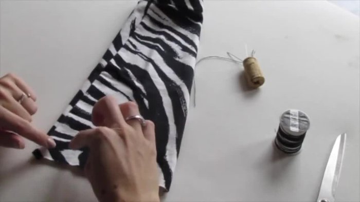 Fold the fabric in half and cut out the pocket shape, ensuring you cut through the seam at the top.