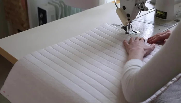 Sew the side and bottom seams of the quilted outer fabric with a 1cm seam allowance. Fold out the bottom corners to create the bag's base and stitch across.