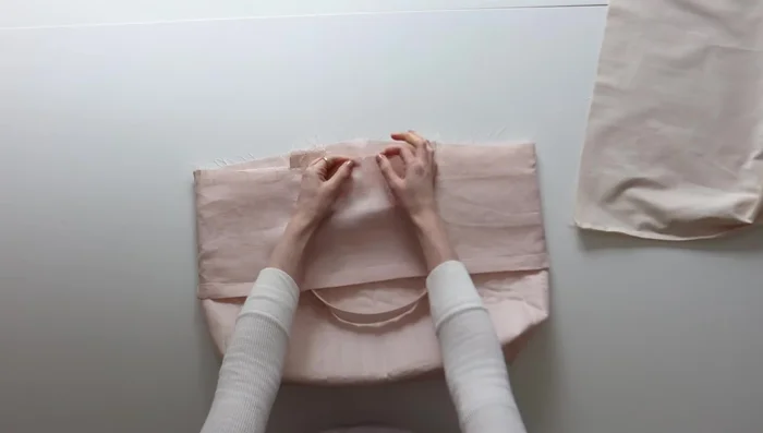 Turn the bag right side out through the gap in the lining, reinforce stitching, and close the gap. Top stitch along the top seam to secure the drawstring and lining.