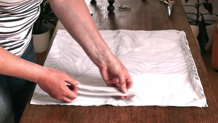 Press the rolled edge of the zipper flat with an iron.