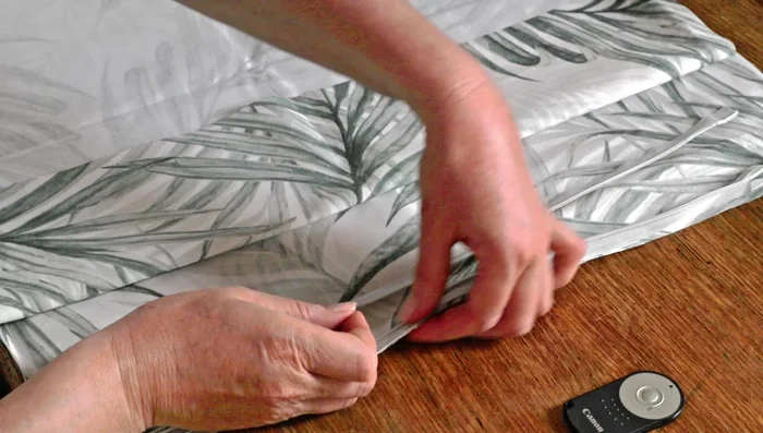 Sew the first side of the invisible zipper to the fabric, removing pins as you go. Keep the needle to the left for easier sewing.