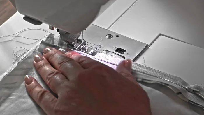 Close the zipper slightly, then sew tightly near the zipper teeth where the zipper pull was.