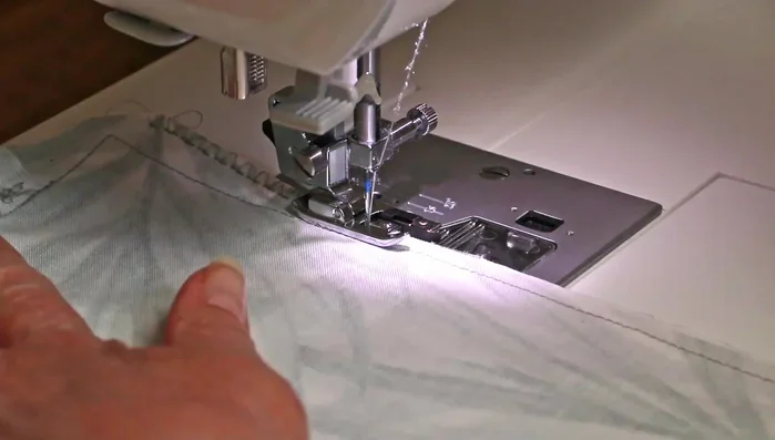 Change to the overlocking foot on your sewing machine and select a zig-zag or overlocking stitch.