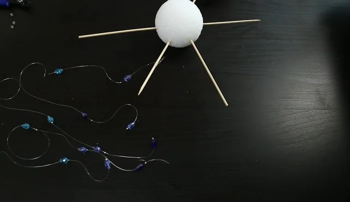 Tie the bead strings onto the skewers, focusing them towards the center. Secure with hot glue.