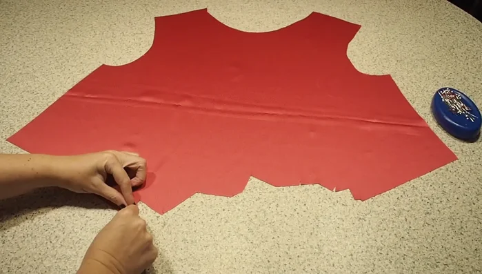 Prepare the front piece: Create pleats along the bottom edge, pin them securely, and tack them in place with a stitching to prevent movement.