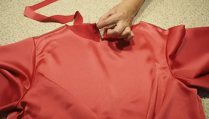 Finish the neckline: Create a bias binding finish for the neckline, sew it in place, trim the excess, and under stitch to keep it neat and flat.